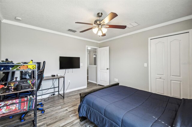 bedroom with a textured ceiling, a closet, ceiling fan, crown molding, and hardwood / wood-style flooring