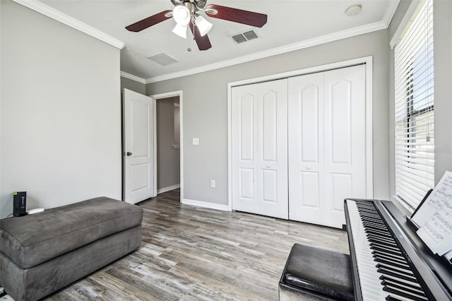 sitting room with crown molding, light hardwood / wood-style flooring, and ceiling fan