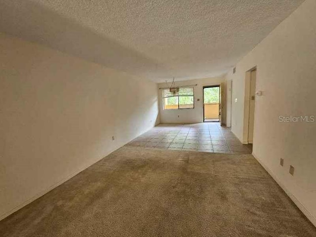 carpeted spare room featuring a textured ceiling