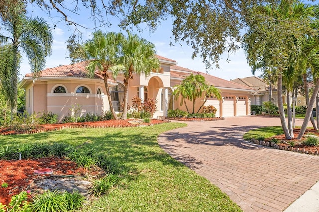 mediterranean / spanish home with a front lawn and a garage