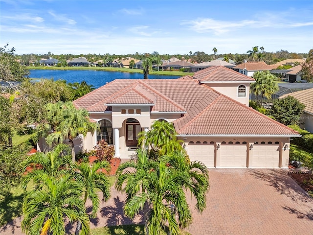 mediterranean / spanish-style house with a water view and a garage