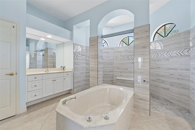 bathroom with tile patterned flooring, vanity, and shower with separate bathtub