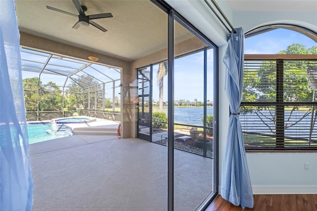 unfurnished sunroom featuring a water view and ceiling fan