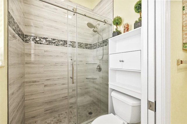 bathroom with toilet and a shower with shower door