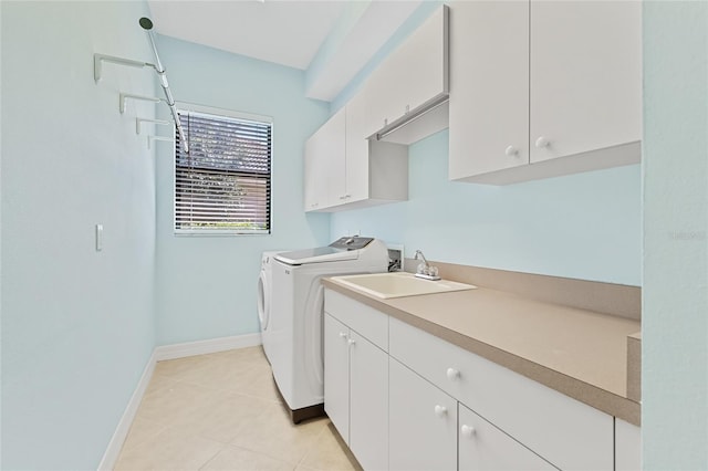 washroom featuring light tile patterned flooring, cabinets, sink, and washing machine and dryer