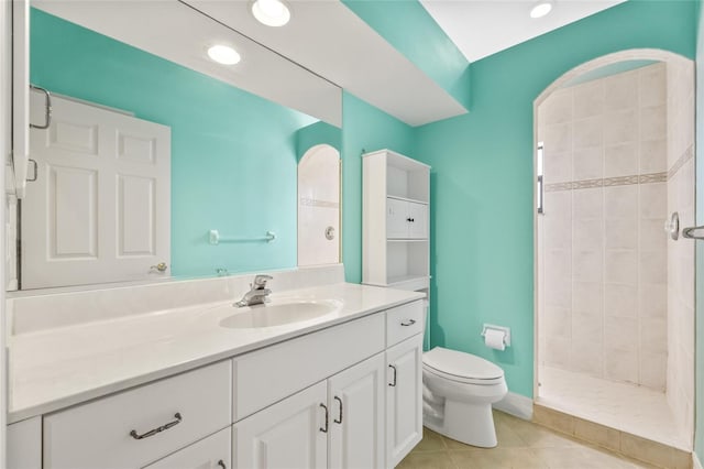 bathroom with tiled shower, tile patterned flooring, vanity, and toilet