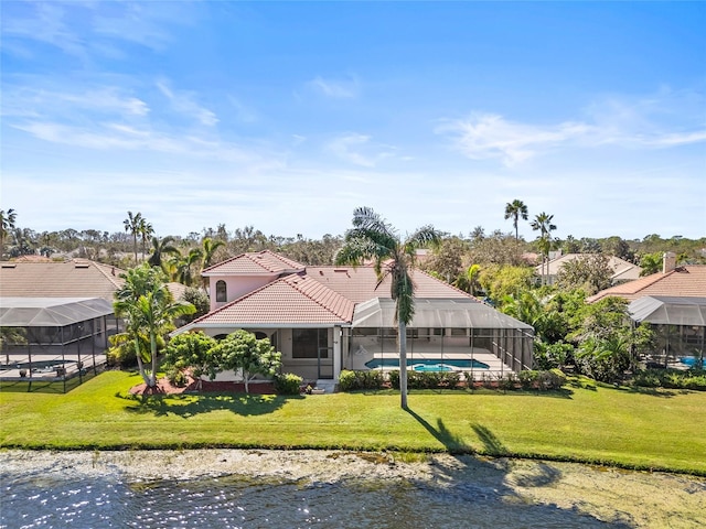 back of property with a lawn, glass enclosure, and a water view