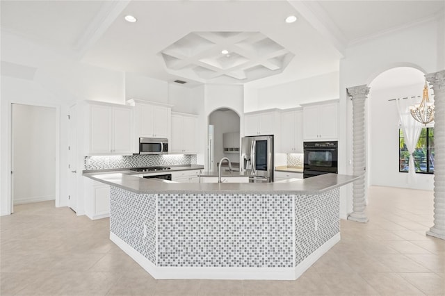 kitchen with a large island, white cabinets, coffered ceiling, and appliances with stainless steel finishes