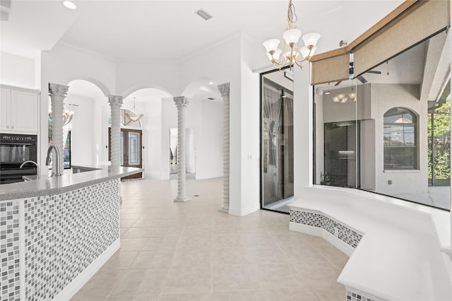 bathroom featuring tile patterned floors, ornate columns, crown molding, and a chandelier