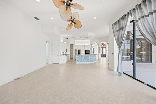 unfurnished living room featuring light tile patterned floors, ceiling fan, and crown molding