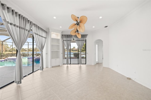 empty room with ornamental molding, a healthy amount of sunlight, and built in features