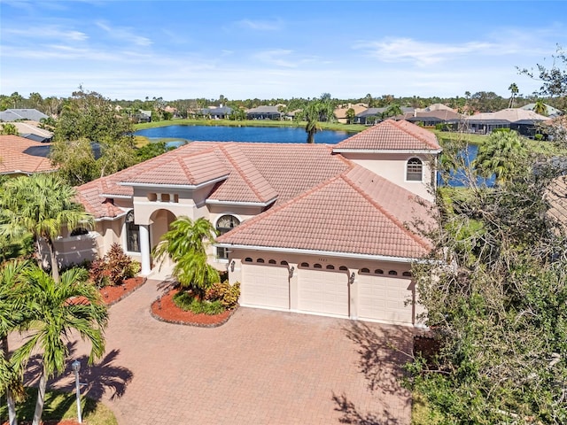 mediterranean / spanish home with a water view and a garage