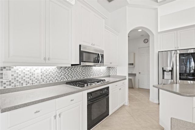 kitchen featuring backsplash, white cabinetry, light tile patterned flooring, and stainless steel appliances