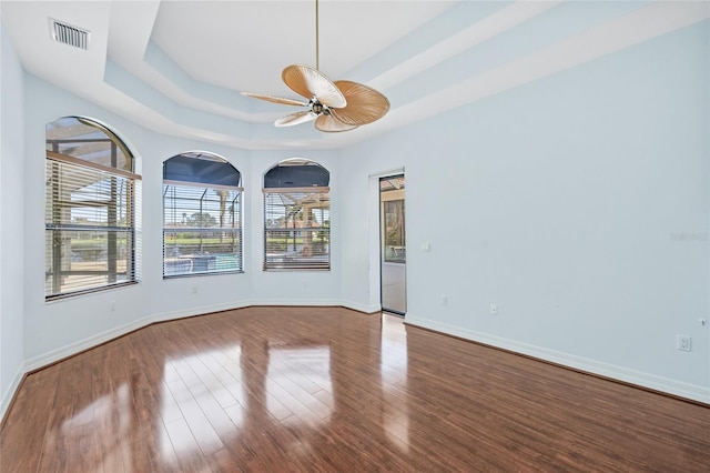 spare room featuring ceiling fan, wood-type flooring, and a tray ceiling