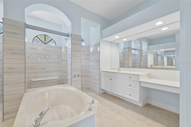 bathroom featuring shower with separate bathtub, vanity, and tile patterned floors