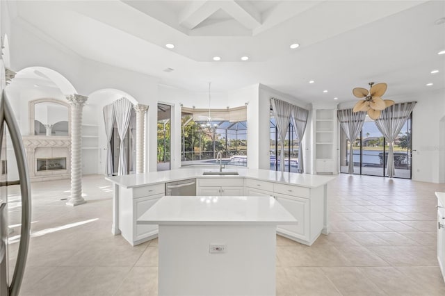 kitchen with sink, built in shelves, a large fireplace, and a kitchen island