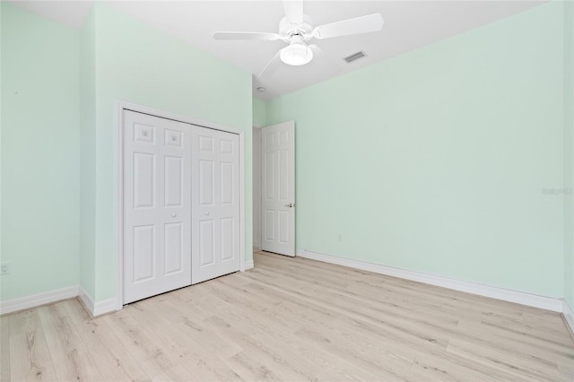 unfurnished bedroom with ceiling fan, a closet, and light wood-type flooring