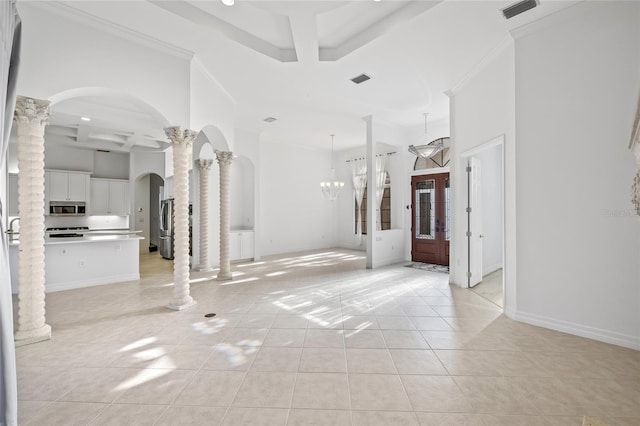 interior space featuring light tile patterned floors, ornamental molding, and ornate columns