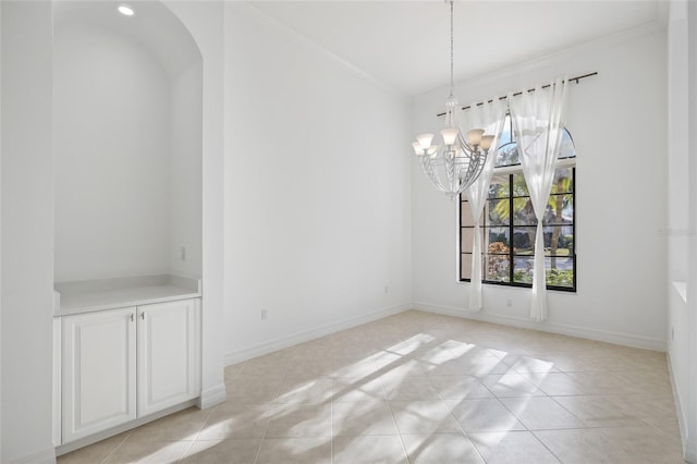 unfurnished dining area with light tile patterned floors, crown molding, and a chandelier