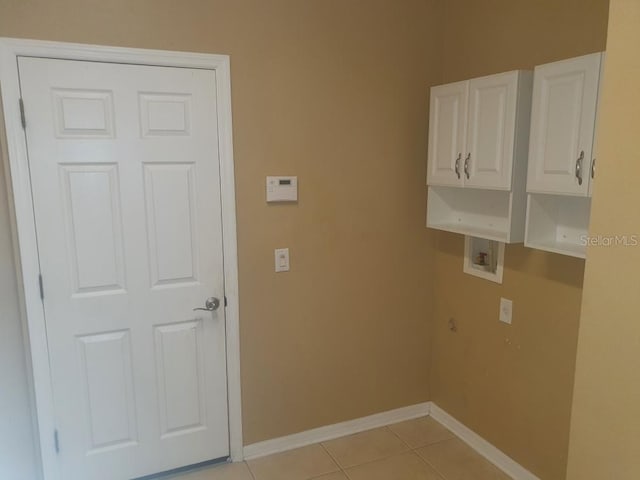 clothes washing area featuring washer hookup, light tile patterned floors, and cabinets