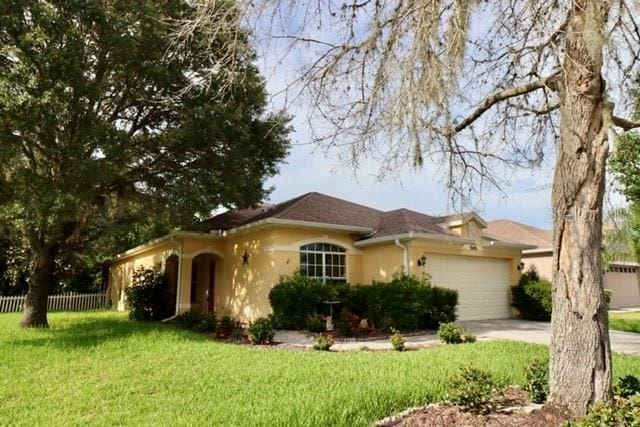 single story home with a garage and a front lawn