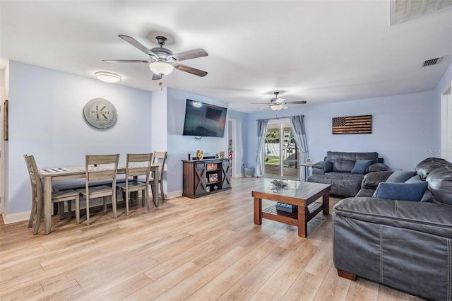 living room with light hardwood / wood-style flooring and ceiling fan