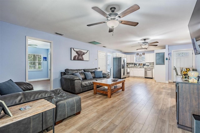 living room featuring ceiling fan and light wood-type flooring