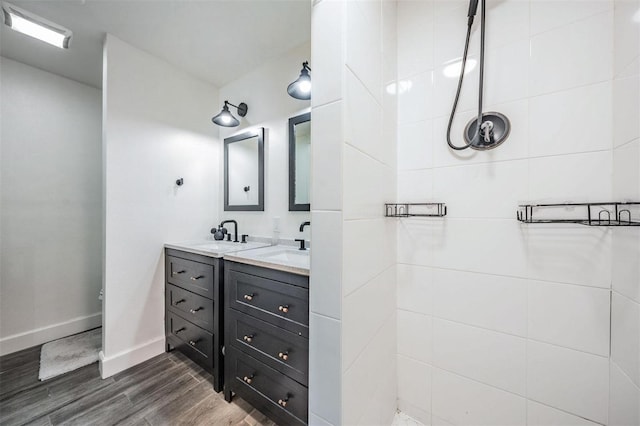 bathroom featuring vanity, wood-type flooring, and tiled shower