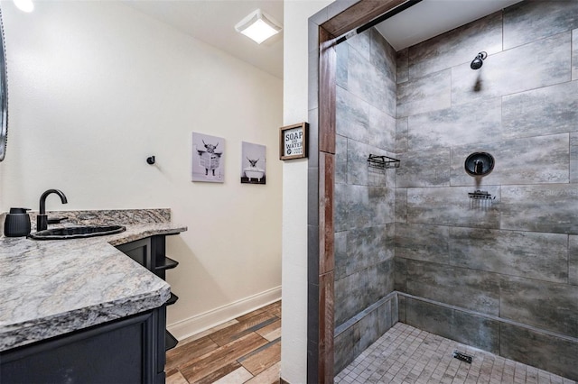 bathroom with vanity, hardwood / wood-style floors, and a tile shower