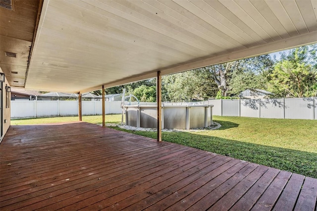 wooden deck with a fenced in pool and a yard