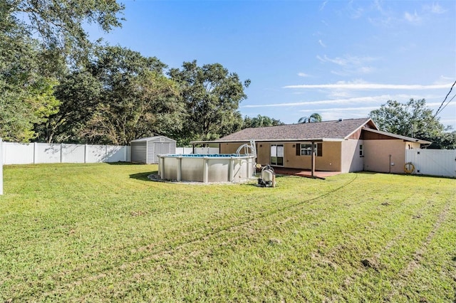 view of yard with a storage shed and a fenced in pool