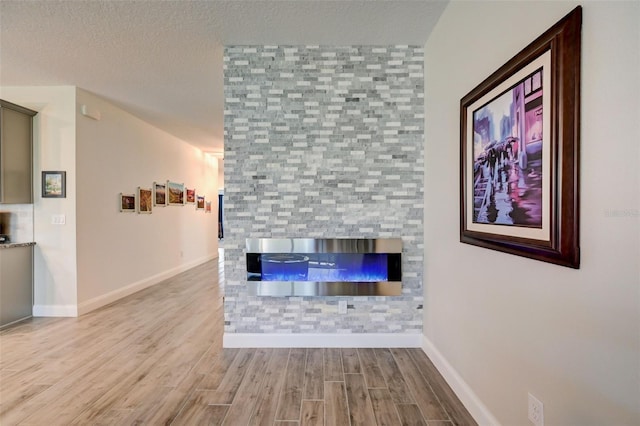 unfurnished living room with a textured ceiling and light wood-type flooring