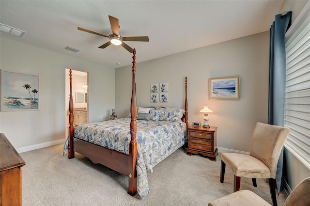 bedroom featuring ceiling fan, ensuite bath, and light carpet