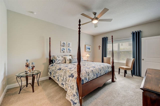 bedroom featuring light carpet, ceiling fan, and a textured ceiling