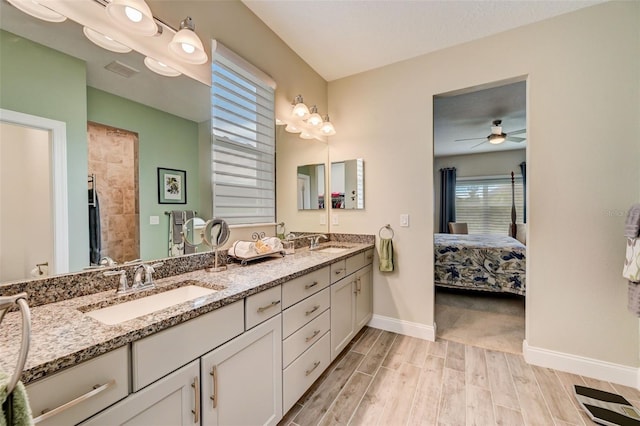 bathroom featuring ceiling fan, walk in shower, and vanity