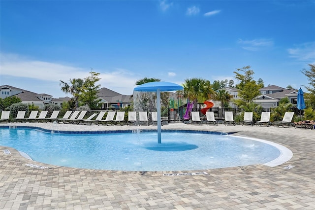 view of pool featuring pool water feature and a playground