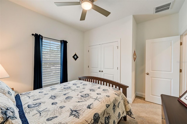 bedroom featuring light carpet, ceiling fan, and a closet