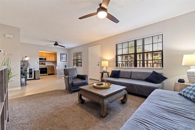 carpeted living room featuring a textured ceiling, a healthy amount of sunlight, and ceiling fan