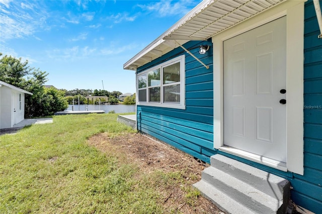 property entrance with a yard and a water view