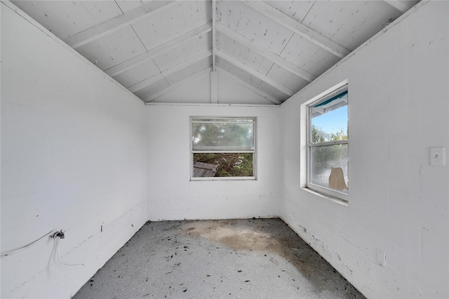 unfurnished room featuring lofted ceiling with beams