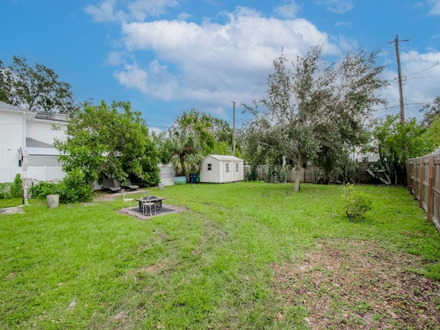 view of yard with a shed and a fire pit