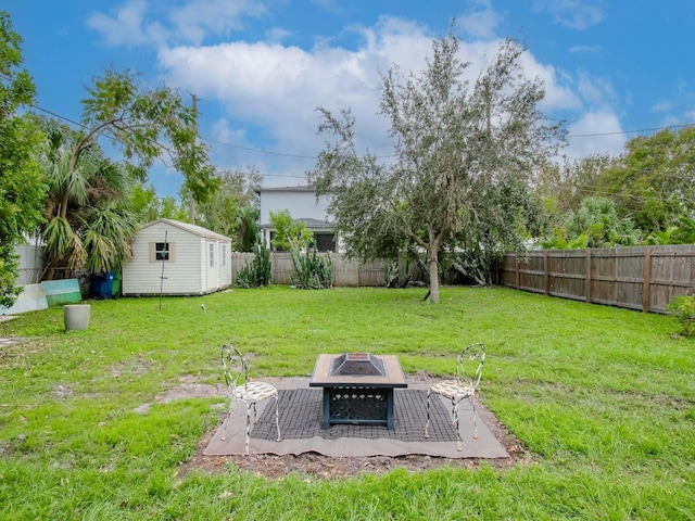 view of yard with a shed and a fire pit