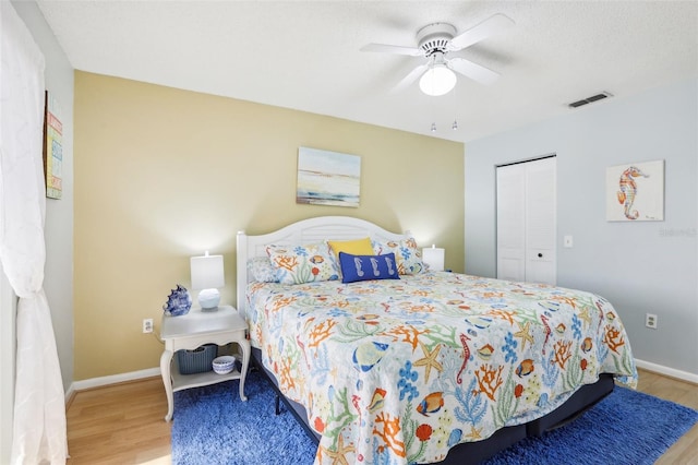 bedroom with a closet, ceiling fan, and light hardwood / wood-style flooring