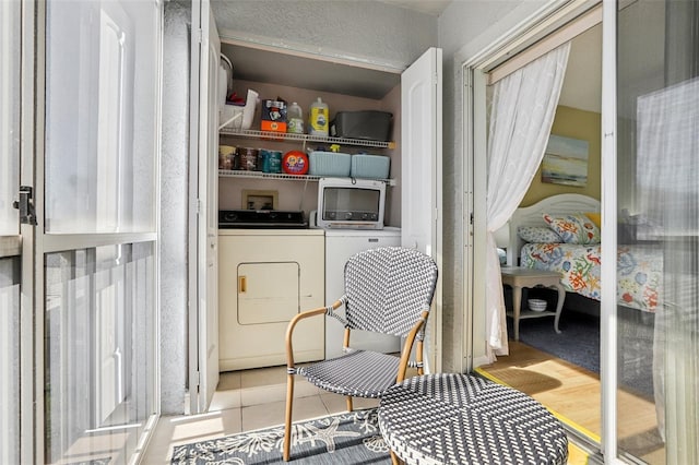 laundry room featuring washer and clothes dryer and light hardwood / wood-style floors