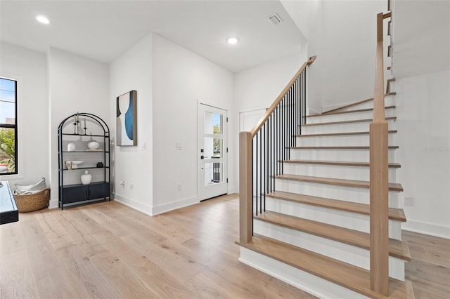 foyer entrance featuring light wood finished floors, stairs, visible vents, and recessed lighting