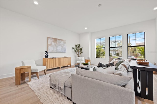 living room with recessed lighting, baseboards, and light wood finished floors