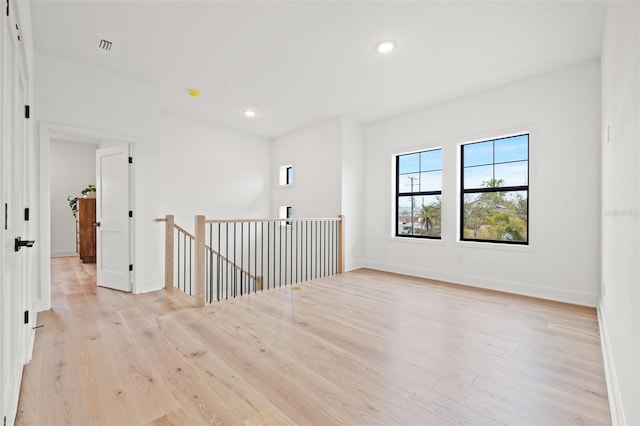 unfurnished room featuring light wood finished floors, visible vents, baseboards, and recessed lighting