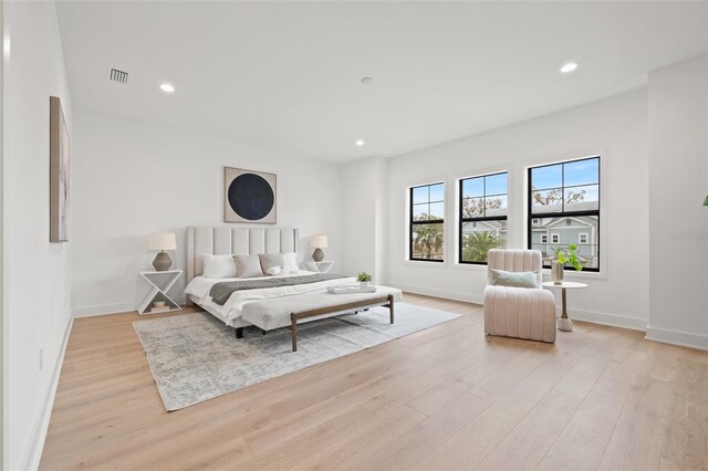 bedroom featuring light wood-type flooring, baseboards, visible vents, and recessed lighting