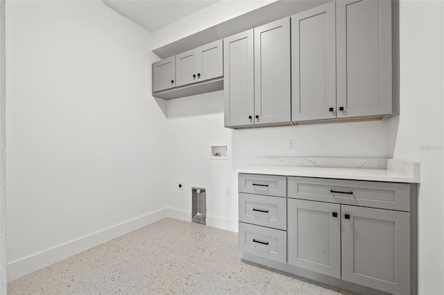 laundry room featuring electric dryer hookup, washer hookup, cabinet space, and baseboards