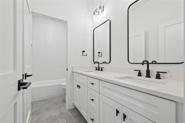 bathroom featuring double vanity, shower / bath combination, toilet, and a sink